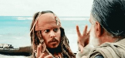 A Man In A Pirate Costume Is Talking To Another Man In Front Of The Ocean . GIF