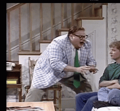A Man In A Plaid Shirt And Tie Is Standing In Front Of A Man In A Green Shirt GIF