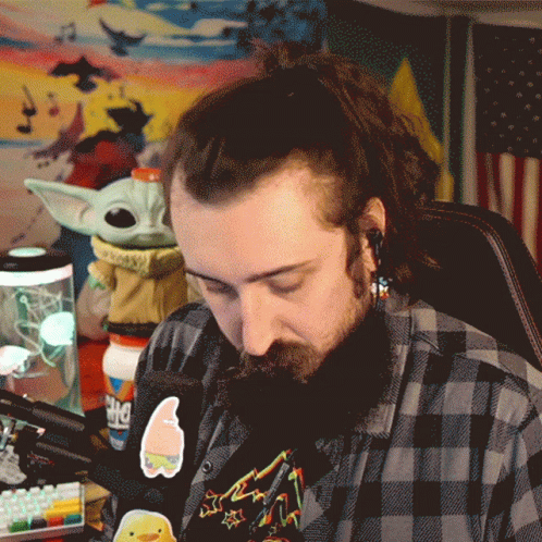 A Man In A Plaid Shirt Has A Sticker On His Shirt That Says Spongebob On It GIF