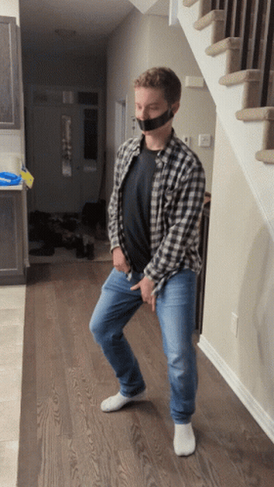 A Man In A Plaid Shirt Has Duct Tape On His Mouth GIF