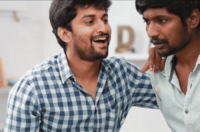 A Man In A Plaid Shirt Has His Arm Around Another Man GIF