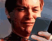 Crying Man In Plaid Shirt Looking At Phone GIF