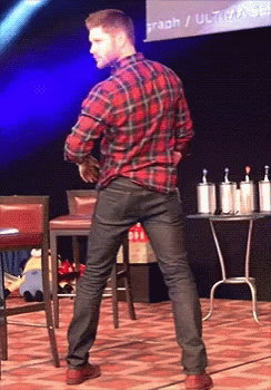 A Man In A Plaid Shirt Is Dancing In Front Of A Screen That Says Graph / Ultracab GIF