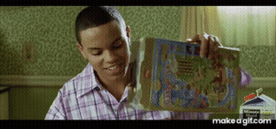 A Man In A Plaid Shirt Is Holding A Box Of Cereal In His Hand . GIF