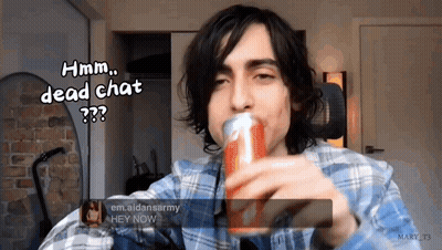 A Man In A Plaid Shirt Is Holding A Can Of Soda And Says Hmm Dead Chat GIF