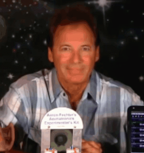 A Man In A Plaid Shirt Is Holding An Aaron Factory 'S Aerialtronics Experimenter 'S Kit GIF