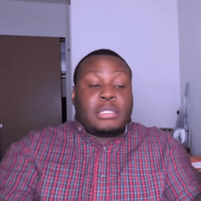 A Man In A Plaid Shirt Is Making A Face GIF