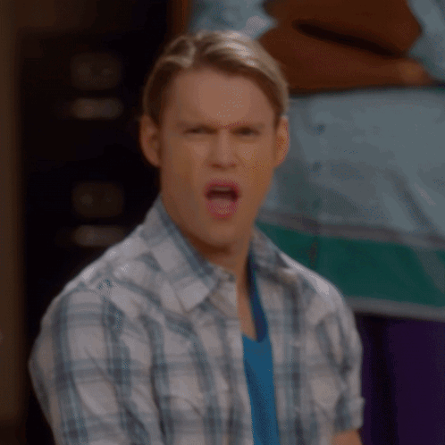 A Man In A Plaid Shirt Is Making A Face GIF