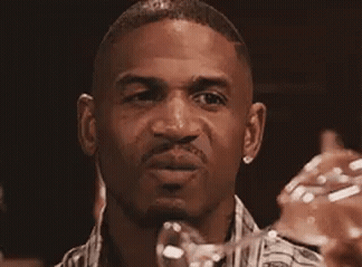 A Man In A Plaid Shirt Is Making A Funny Face . GIF