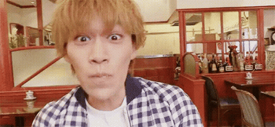 A Man In A Plaid Shirt Is Making A Funny Face In Front Of A Restaurant . GIF