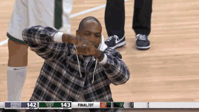 A Man In A Plaid Shirt Is Making A Funny Face In Front Of A Scoreboard That Says 143 Final / Ot GIF