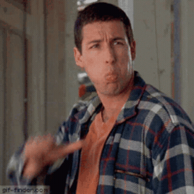 A Man In A Plaid Shirt Is Making A Funny Face While Pointing At The Camera . GIF