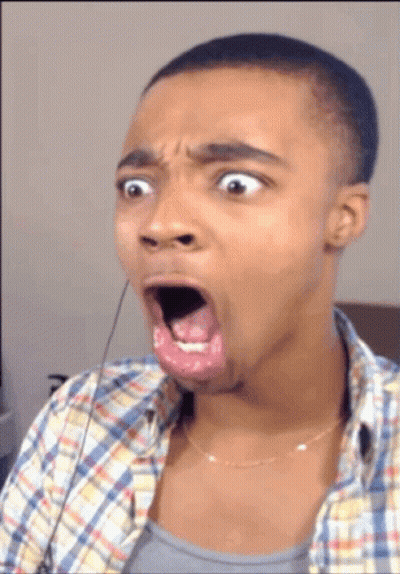 A Man In A Plaid Shirt Is Making A Funny Face With His Mouth Open GIF