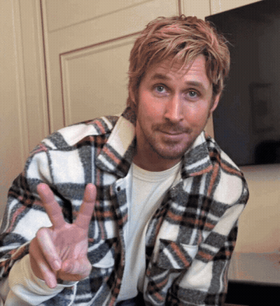 A Man In A Plaid Shirt Is Making A Peace Sign GIF