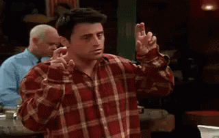 A Man In A Plaid Shirt Is Making A Peace Sign With His Hands . GIF