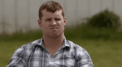 A Man In A Plaid Shirt Is Making A Serious Face GIF