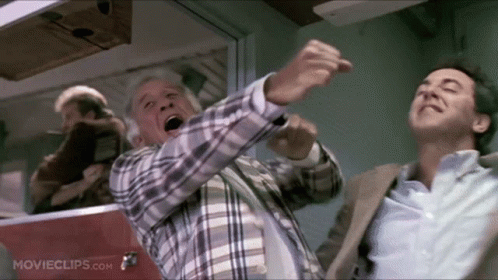 A Man In A Plaid Shirt Is Pointing At Another Man In A Suit In A Movie Clip From Movieclips.com GIF