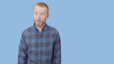 A Man In A Plaid Shirt Is Pointing Up And The Words Brilliant Are Behind Him GIF