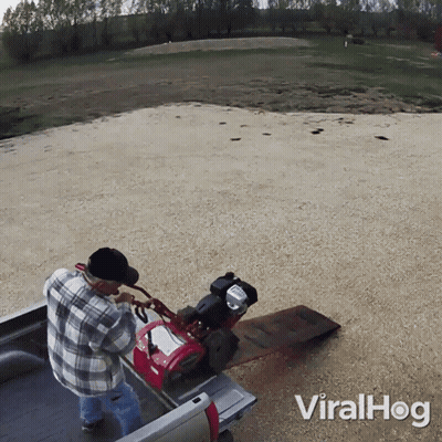 A Man In A Plaid Shirt Is Pushing A Lawn Mower In The Back Of A Truck That Says Viralhog On The Bottom GIF