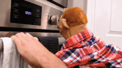 A Man In A Plaid Shirt Is Putting A Towel On A Towel Rack In Front Of An Oven That Says 12:31 GIF