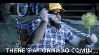 A Man In A Plaid Shirt Is Sitting In A Chair Holding A Lollipop . GIF