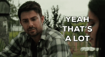 A Man In A Plaid Shirt Is Sitting Next To A Woman In A Cemetery . GIF