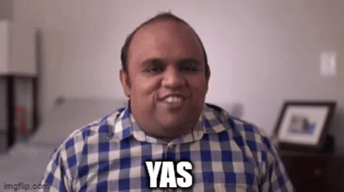 A Man In A Plaid Shirt Is Smiling With The Word Yas On His Face . GIF
