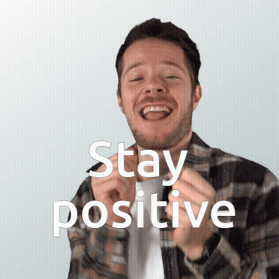 A Man In A Plaid Shirt Is Smiling With The Words Stay Positive Above Him GIF