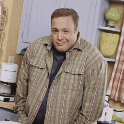A Man In A Plaid Shirt Is Standing In A Kitchen With His Hands In His Pockets GIF