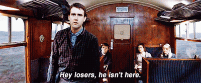 A Man In A Plaid Shirt Is Standing In A Train Car And Says Hey Losers He Is N't Here GIF