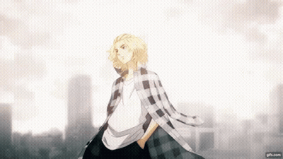 A Man In A Plaid Shirt Is Standing In Front Of A City Skyline With His Hands In His Pockets . GIF