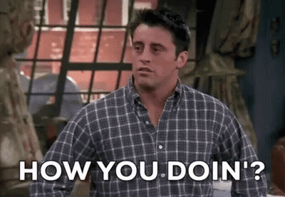 A Man In A Plaid Shirt Is Standing In Front Of A Window And Asking How You Doin ' ? GIF