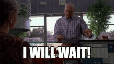 A Man In A Plaid Shirt Is Standing In Front Of A Woman In An Office And Says `` I Will Wait ! '' GIF