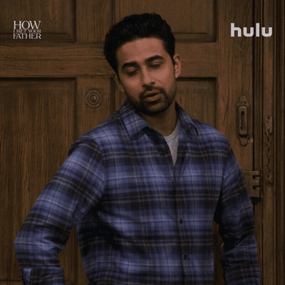 A Man In A Plaid Shirt Is Standing In Front Of A Wooden Door And Says No Big Deal GIF