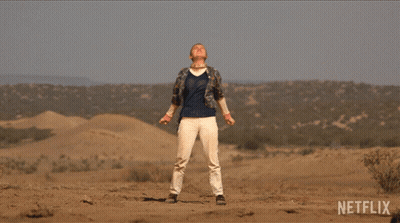A Man In A Plaid Shirt Is Standing In The Desert With A Netflix Logo In The Corner GIF
