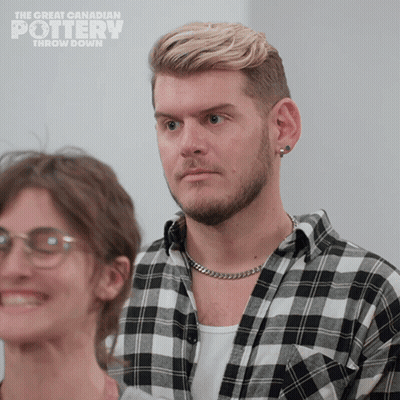 A Man In A Plaid Shirt Is Standing Next To A Woman With Glasses And The Words The Great Canadian Pottery Throw Down GIF