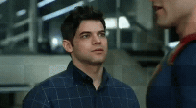A Man In A Plaid Shirt Is Standing Next To Another Man In A Superman Costume . GIF