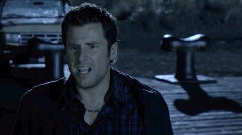 A Man In A Plaid Shirt Is Standing On A Wooden Dock Looking At Something . GIF