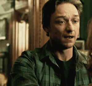 A Man In A Plaid Shirt Is Talking To A Woman In A Dark Room . GIF