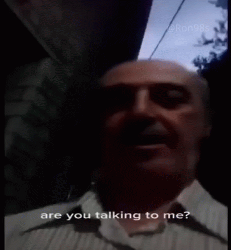 A Man In A Plaid Shirt Is Talking To Someone And Says Are You Talking To Me ? GIF