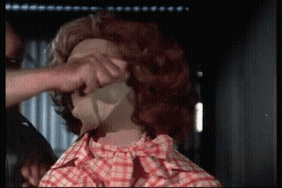 A Man In A Plaid Shirt Is Touching A Woman 'S Face GIF