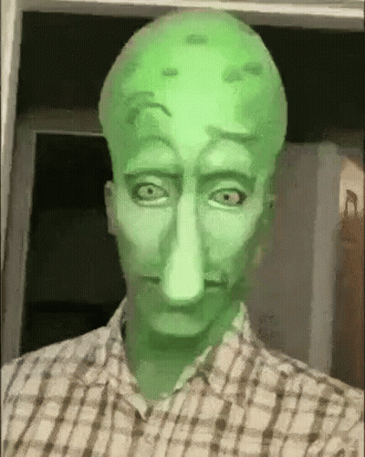 A Man In A Plaid Shirt Is Wearing A Squidward Mask . GIF