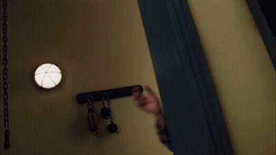 A Man In A Plaid Shirt Reaches Out His Hand Towards The Camera GIF