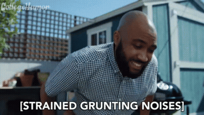 A Man In A Plaid Shirt Says Strained Grunting Noises In Front Of A Shed GIF
