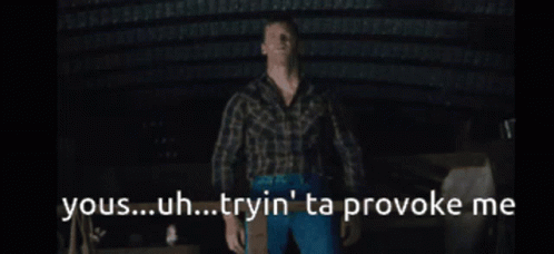 A Man In A Plaid Shirt Stands In A Dark Room With The Words Yous Uh Tryin ' Ta Provoke Me GIF