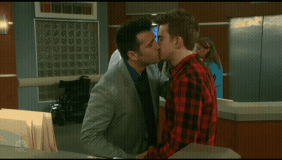A Man In A Plaid Shirt Talks To A Man In A Suit GIF