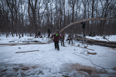 A Man In A Plaid Shirt Walks In The Snow GIF