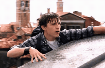 A Man In A Plaid Shirt With A Backpack Leaning Over A Ledge GIF
