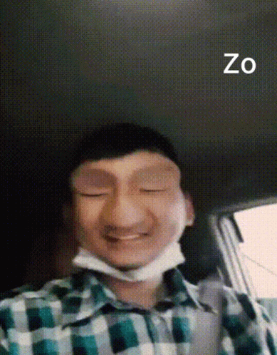 A Man In A Plaid Shirt With A Mask On His Face And The Word Zo On The Bottom Right GIF