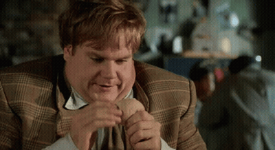 a man in a plaid suit is eating a hot dog
